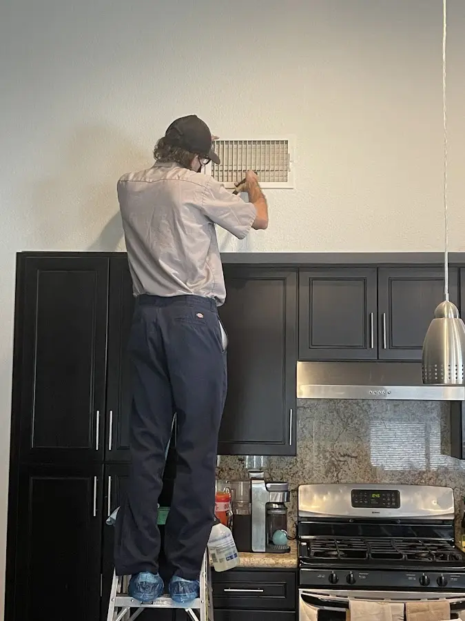 Technician inspecting an air vent during HVAC service in Garwood